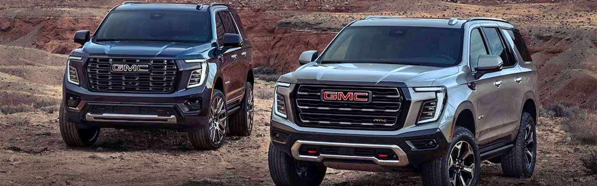 2025 GMC Yukon parked in a rugged desert landscape, highlighting GMC’s bold grille design, premium off-road capability, and luxury full-size SUV performance