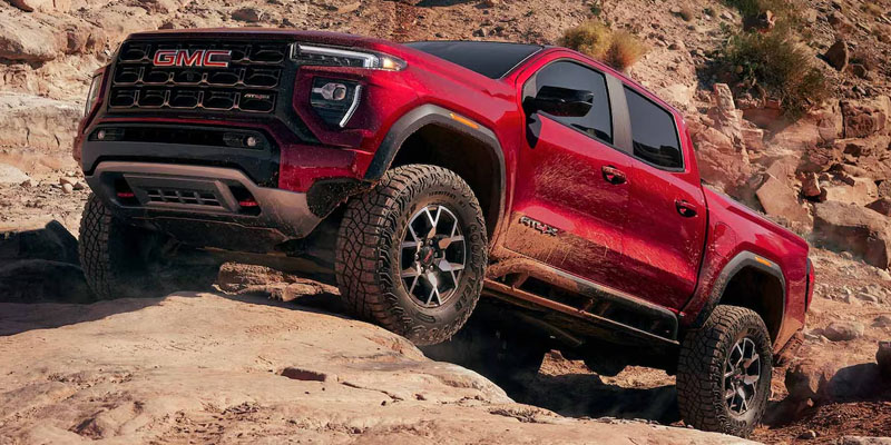 2026 GMC Canyon driving through rocky terrain in Las Vegas, showcasing its rugged capabilities and off-road performance.